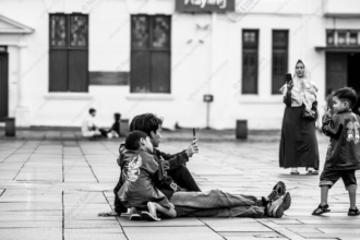 A Father and Child Seated in the Plaza