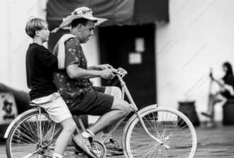Man and Boy on a Shared Bicycle