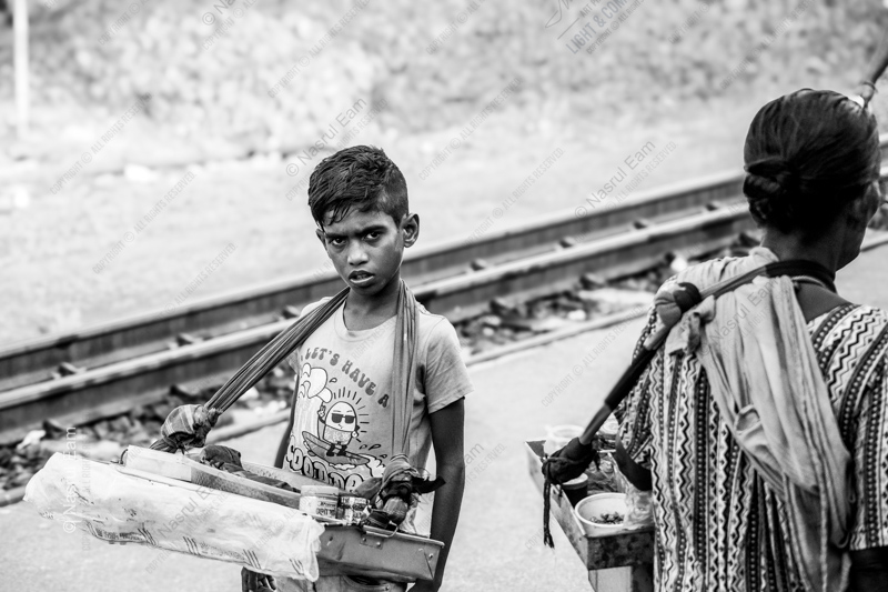 Young Vendor by the Railway Tracks
