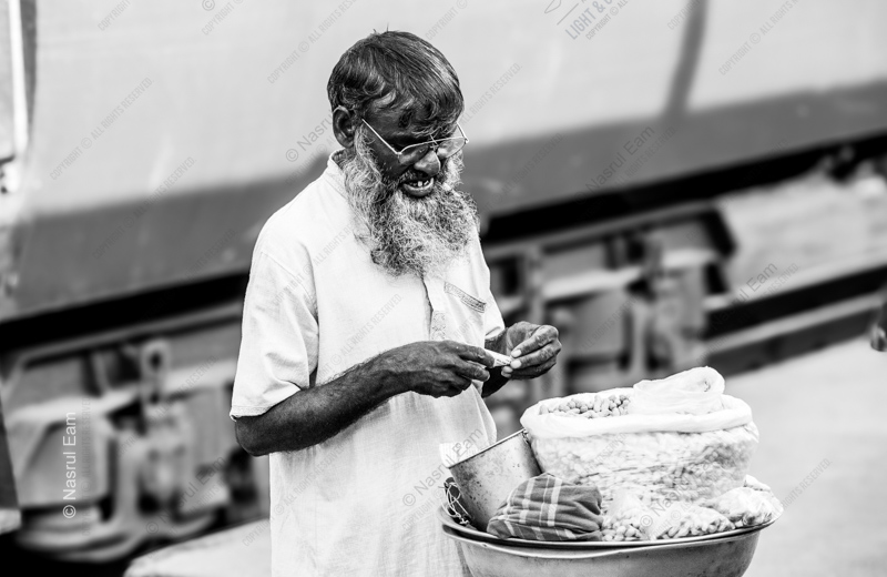 An Elderly Vendor Preparing His Goods