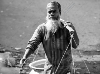 Man with a Carrying Yoke - monochrome photography, human portraiture, cultural documentation, visual storytelling, light and composition, fine art photography