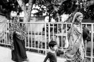 An Elder, a Woman, and a Child by the Roadside