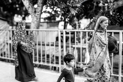 An Elder, a Woman, and a Child by the Roadside