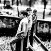 Three Boys on a Weathered Fence