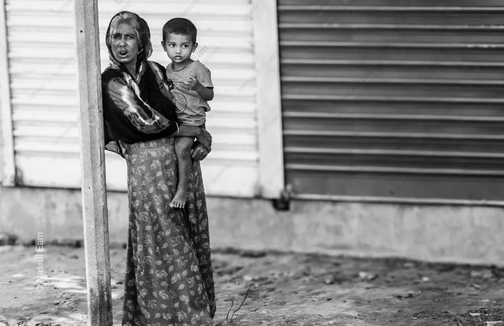 Woman Holding a Child by a Shuttered Wall
