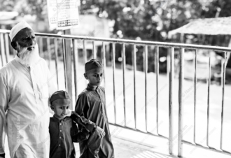 An Elder and Two Boys Beside a Railing