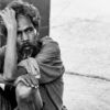 A Man Seated on the Pavement