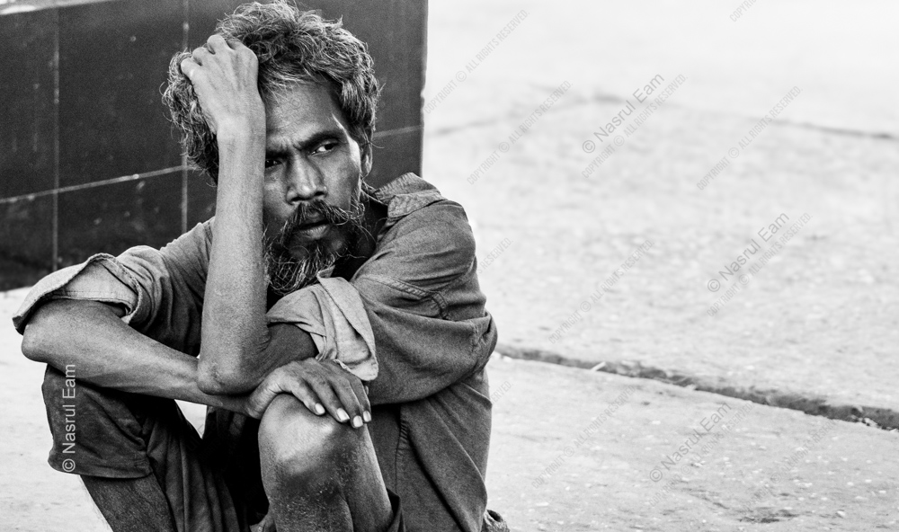 A Man Seated on the Pavement