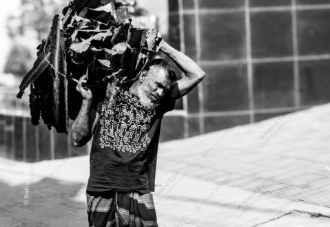 A Man Beneath the Weight of Scrap Metal