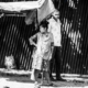 A Woman with a Crutch Beside a Corrugated Wall nasrul eam 20251020 Dhaka Rajshahi Tour 20 21 EN1 4582