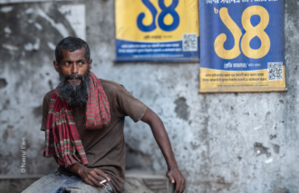Man with Red Scarf Before a Wall of Posters