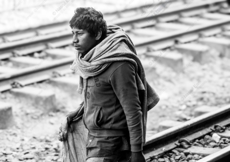 Young Man Walking Along the Railway Tracks