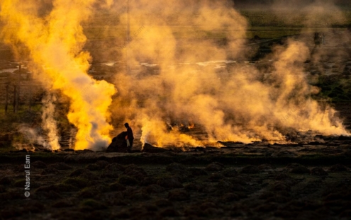Silhouetted Laborer in the Golden Smoke