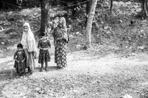 A Mother and Children Standing in the Shade of Trees