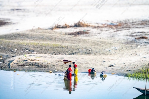 Two Women Washing Clothes in the Riverbank Shallows