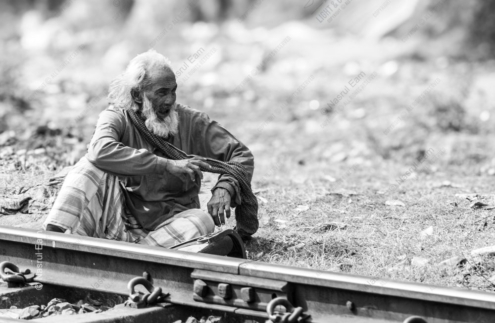 Elderly Man Resting Beside the Railway Tracks