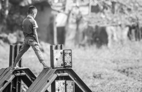 A Young Boy Balancing on Steel Rail Components